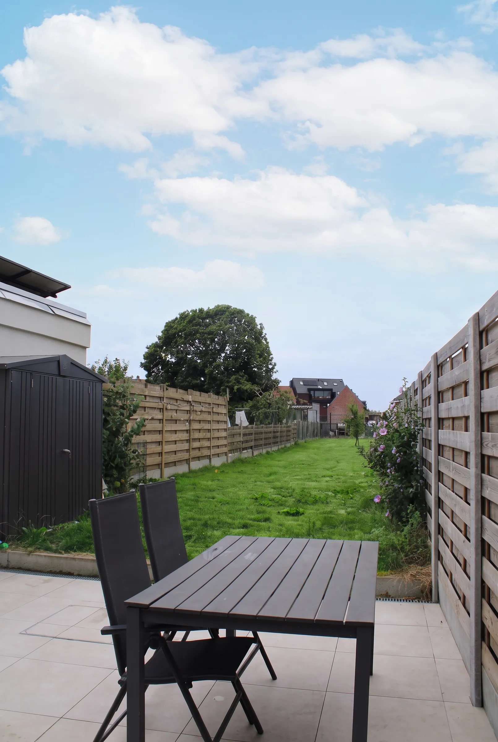 Natuurstenen terras met tuintafel en zicht op de tuin
